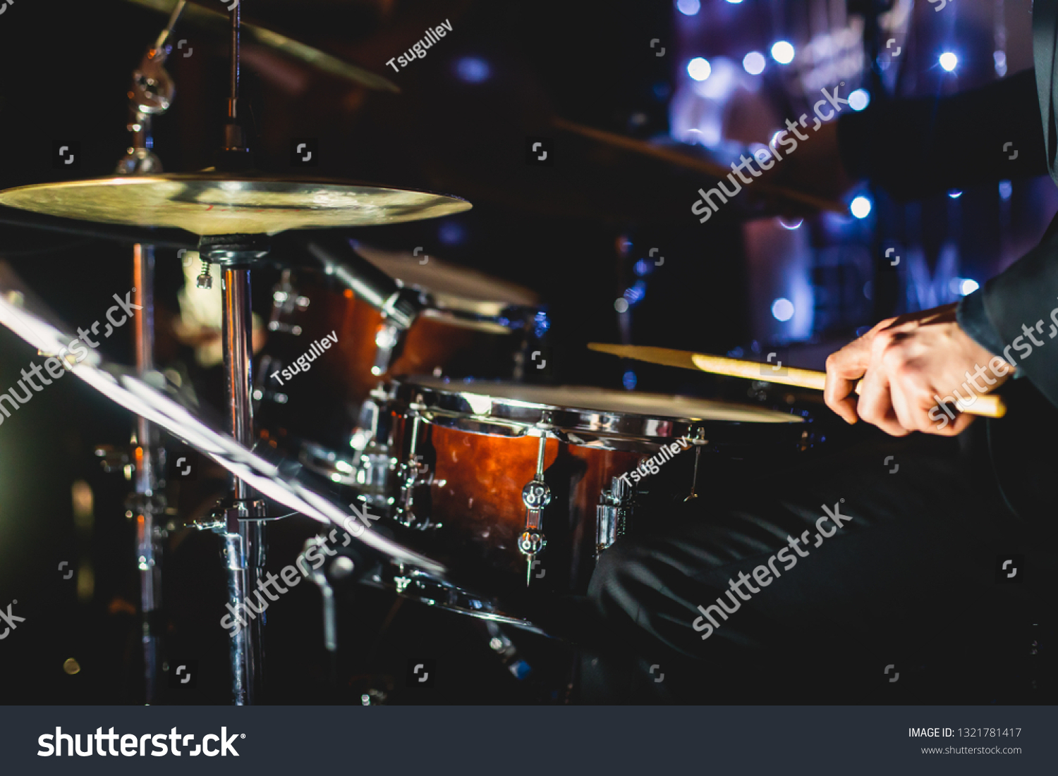 View of drum set kit on a stage during jazz rock show performance, with band performing in the background, drummer point of view 
 #1321781417