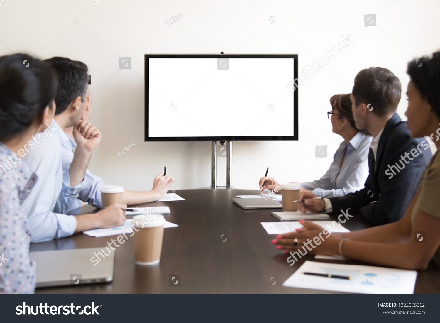 Business executive people group sitting at conference table looking at white blank mockup tv screen on wall watching presentation in meeting room, company training corporate team seminar in boardroom #1322055362