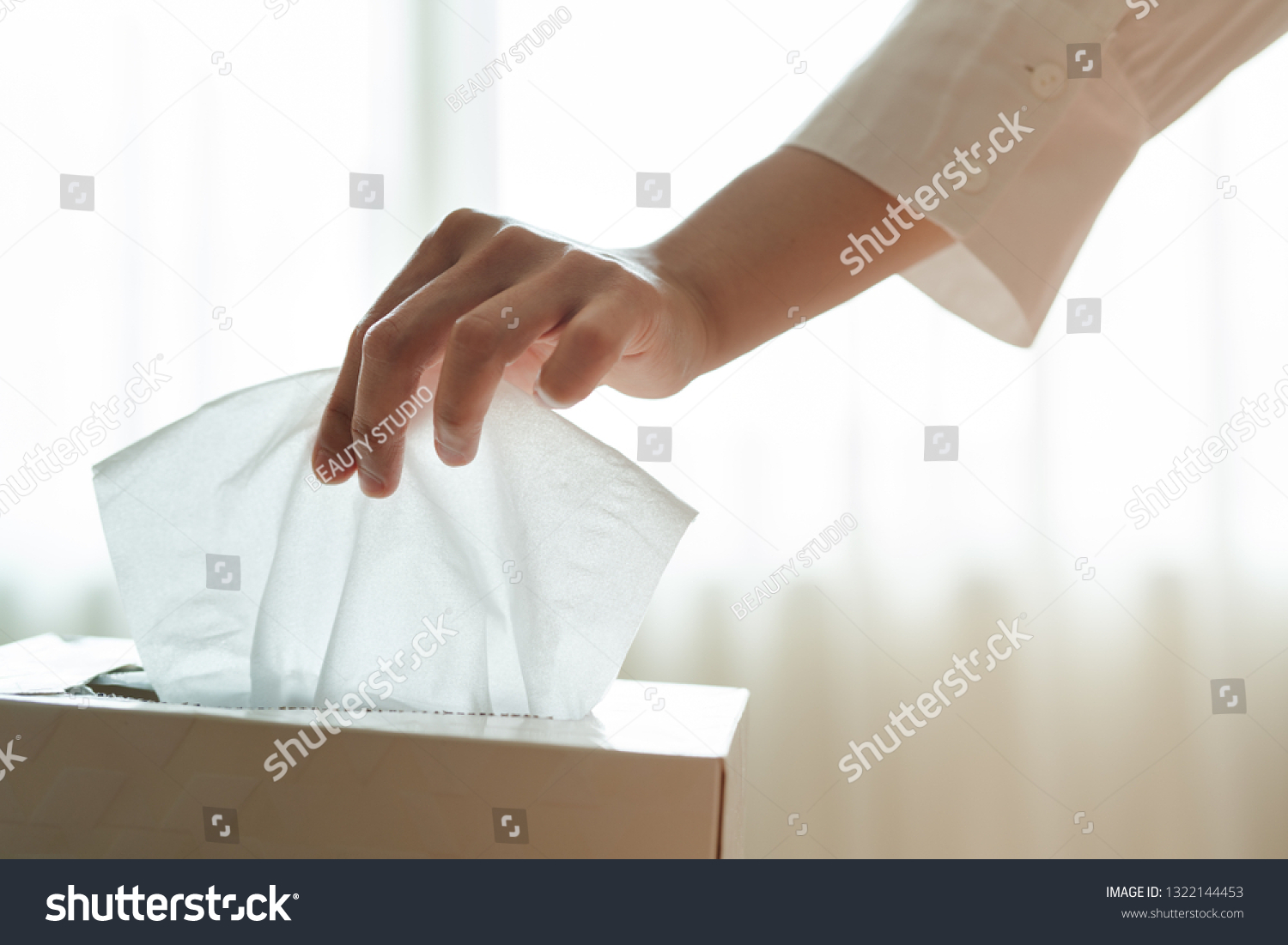 women hand picking napkin/tissue paper from the tissue box #1322144453