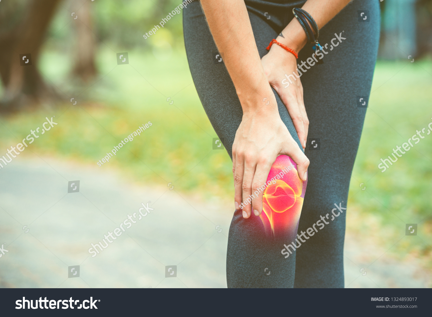Woman holding her knee with red pain on the skeleton #1324893017
