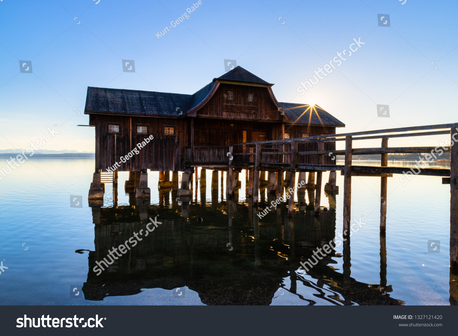 A boatshouse at a lake at sunset #1327121420