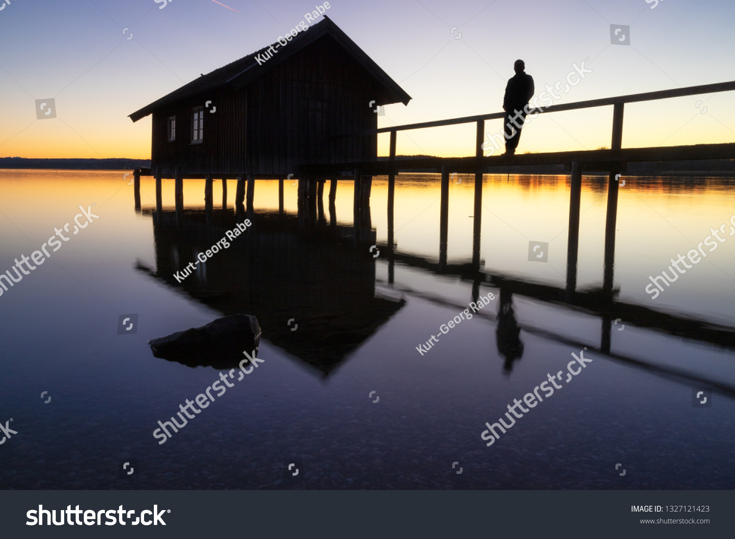A boatshouse at a lake at sunset #1327121423