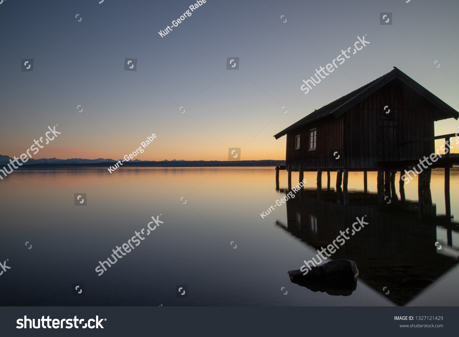 A boatshouse at a lake at sunset #1327121429
