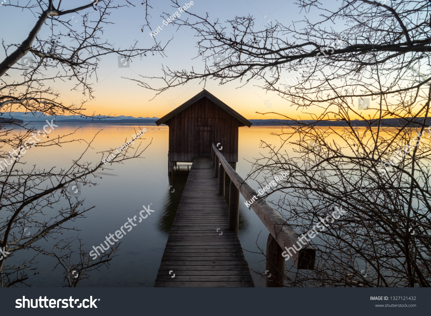A boatshouse at a lake at sunset #1327121432