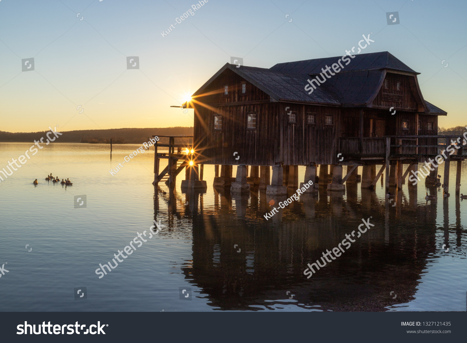 A boatshouse at a lake at sunset #1327121435