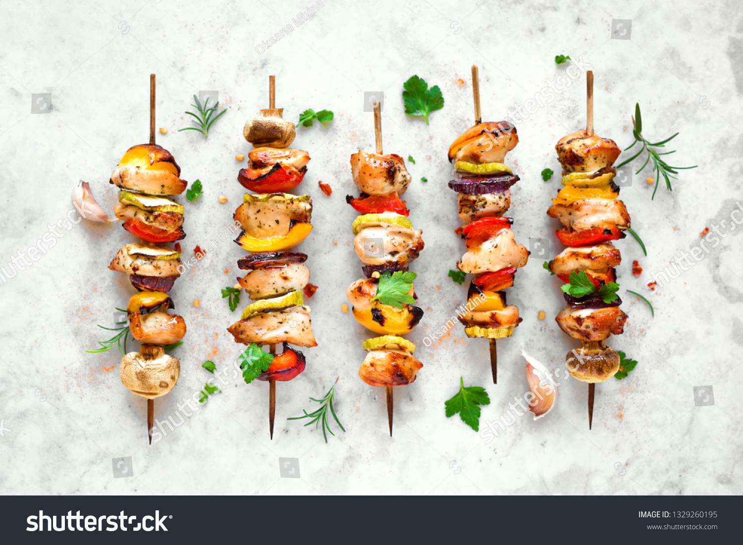 Grilled vegetable and chicken skewers with  bell peppers, zucchini, onion and mushrooms on white marble background, top view. Meat and vegetables kebabs on skewers. #1329260195