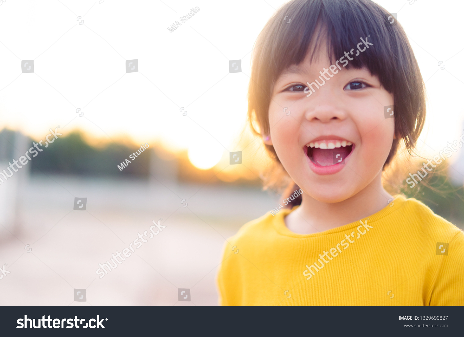 Happy Little asian girl child showing front teeth with big smile and laughing: Healthy happy funny smiling face young adorable lovely female kid.Joyful portrait of asian elementary school student.  #1329690827