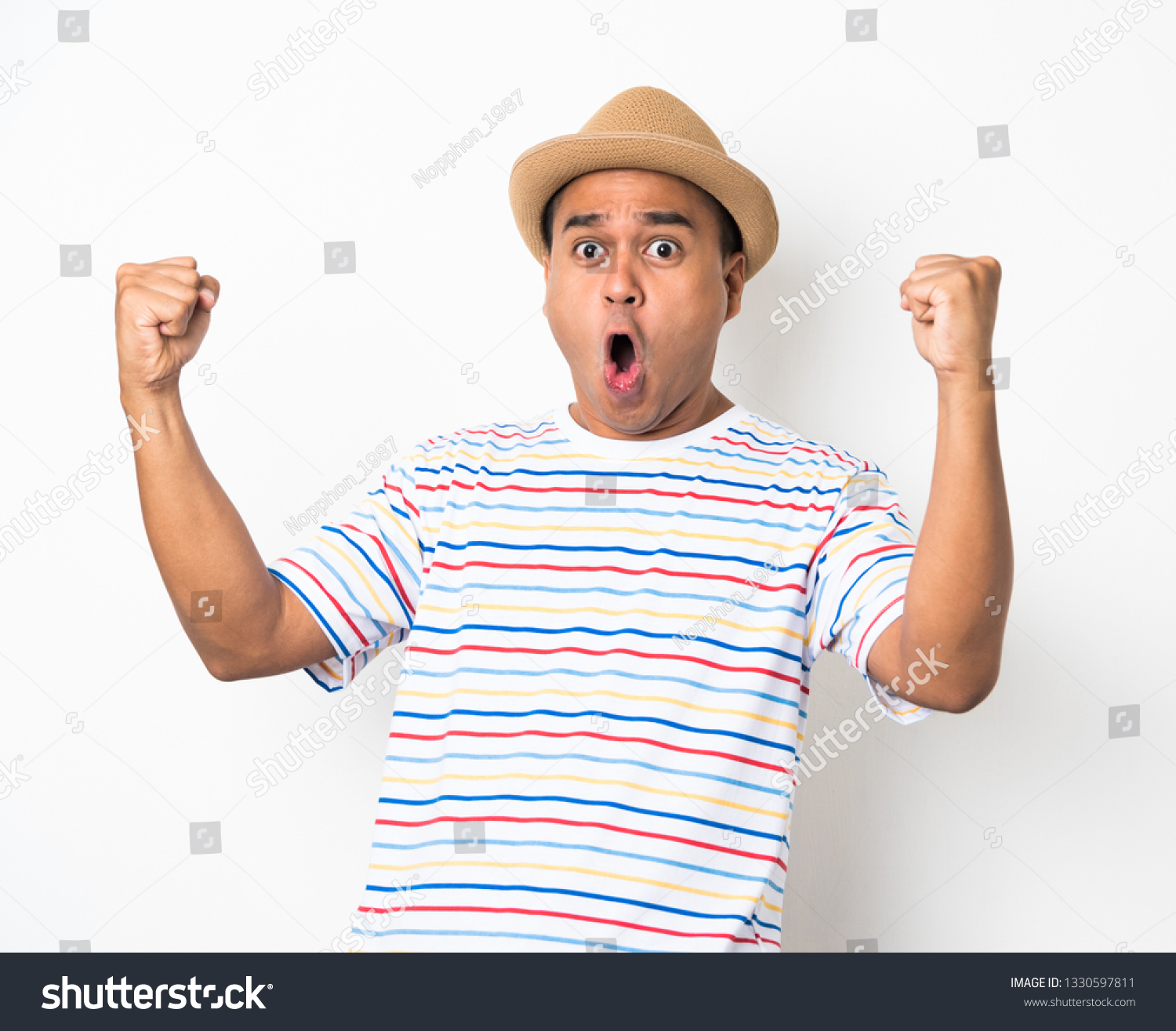 Happy young asian man celebrates with two hand in the air on isolate white background. #1330597811