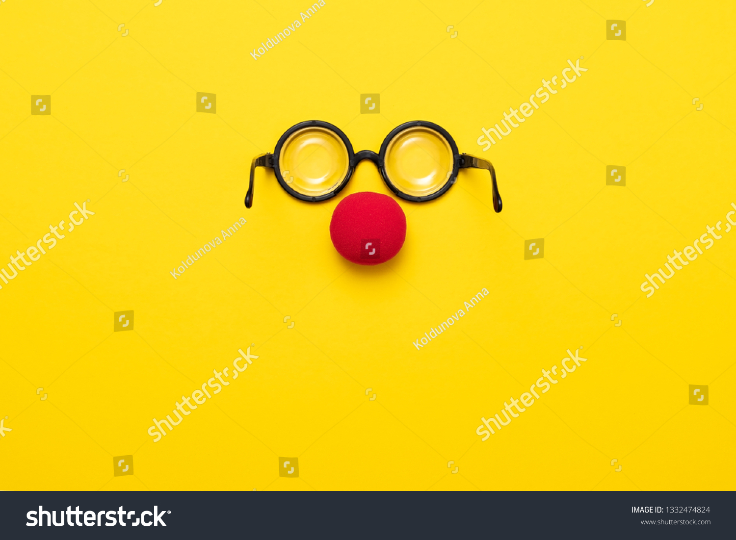 Funny glasses, a red clown nose and tie on a colored background, like a face. Flat lay. Funny costume for the holidays. Anonymous concept. #1332474824