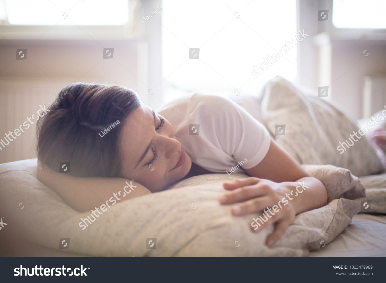 There's nothing better than a lie in. Woman sleeping in bed. #1333479989