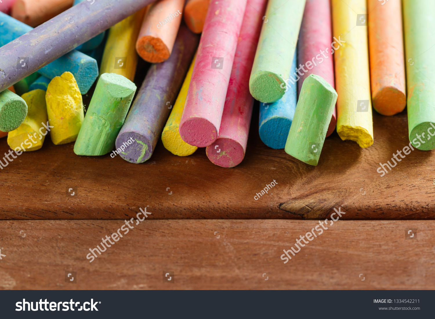 Multiple colorful chalk on wooden floors with copy space #1334542211