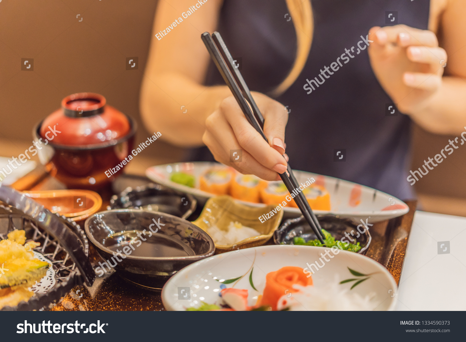 Woman eating japanese food in a japanese food restaurant #1334590373