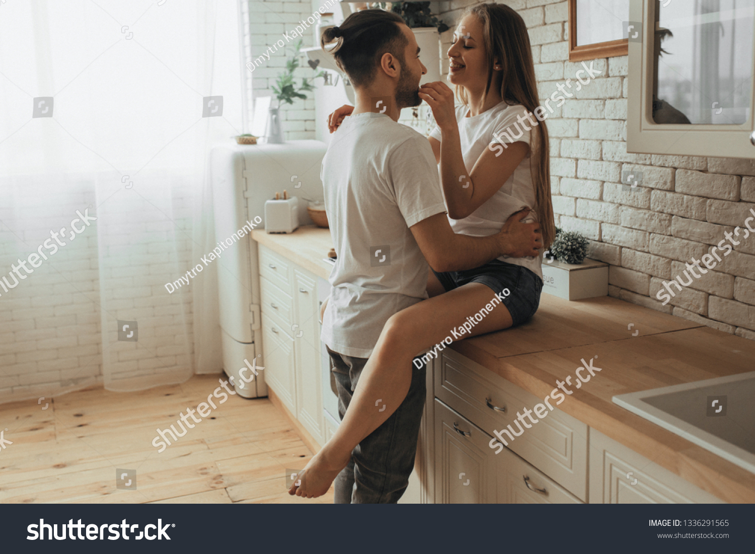 Beautiful loving couple kissing in kitchen #1336291565