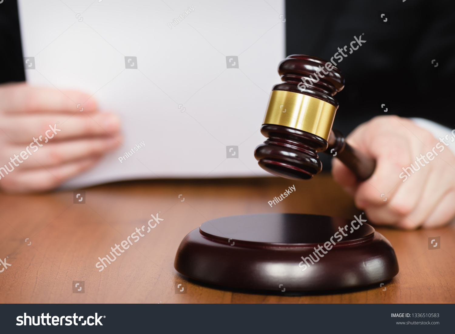 Judge's gavel in hand. Judge passes sentence. Lawyer and court. Judge hits the table with hammer. In the courtroom, the judge convicted lawyer. #1336510583