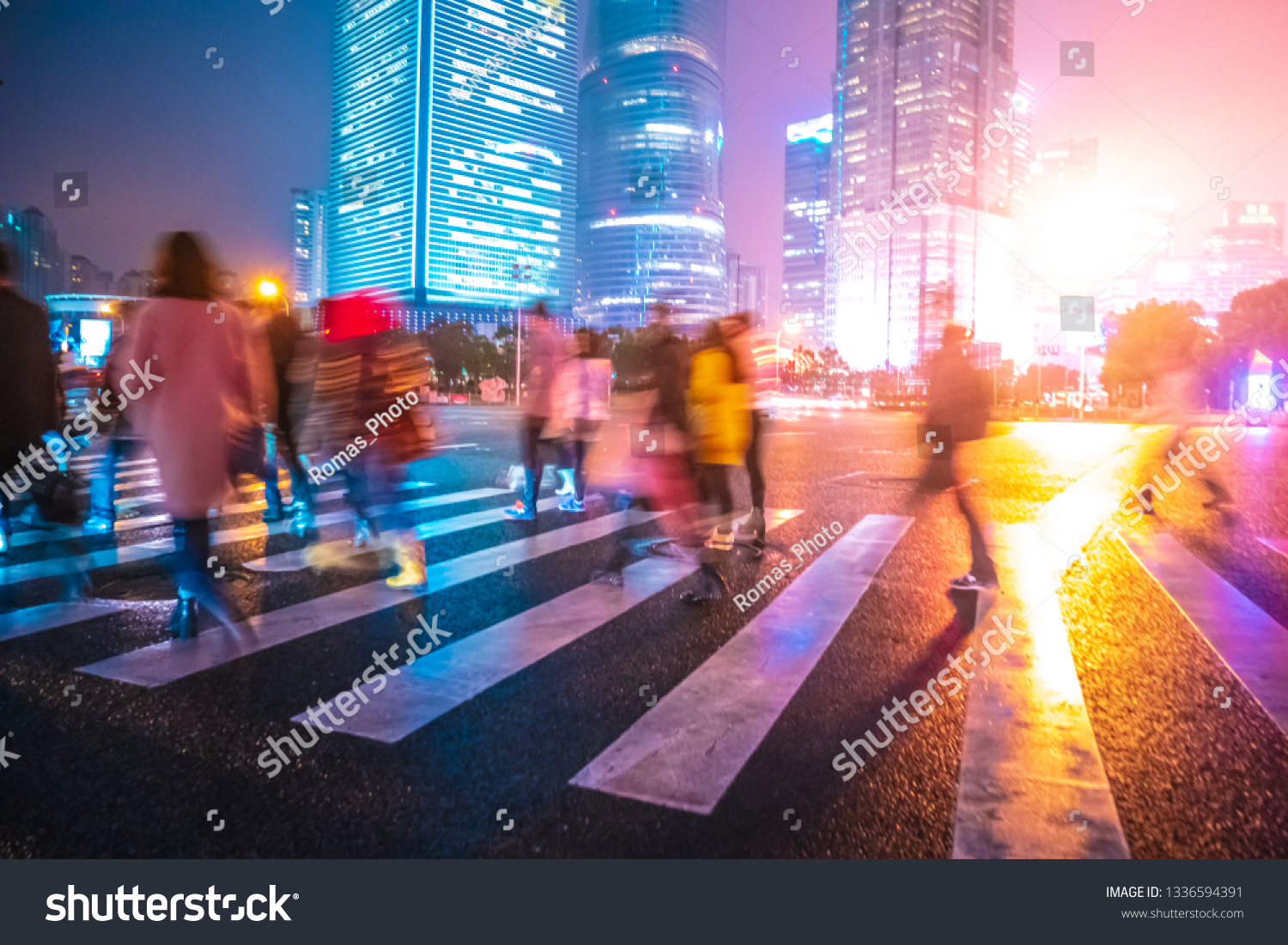 Abstract background of People across the crosswalk at night in Shanghai, China. Perfect background image of blurred night street with unrecognizable people and cars in night illumination  #1336594391