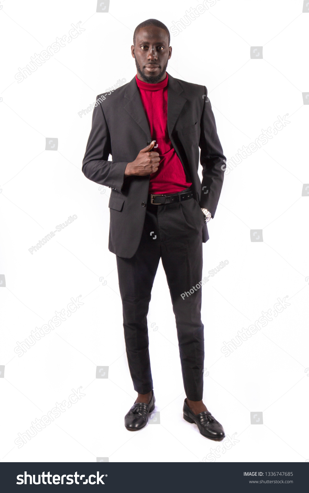 Young and handsome. Handsome young African senegalese man in smart casual jacket holding hands in pockets and traditional smiling while standing against white background #1336747685