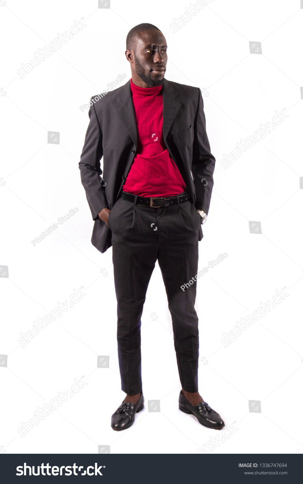 Young and handsome. Handsome young African senegalese man in smart casual jacket holding hands in pockets and traditional smiling while standing against white background #1336747694