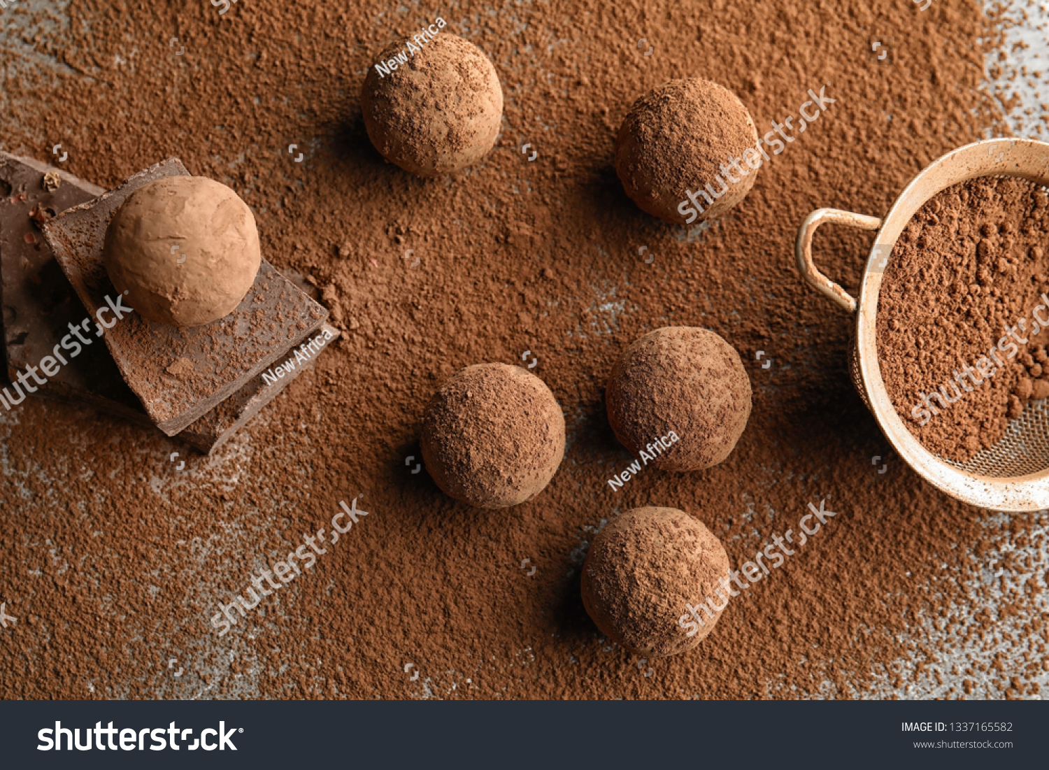 Flat lay composition with chocolate truffles powdered with cacao on table #1337165582