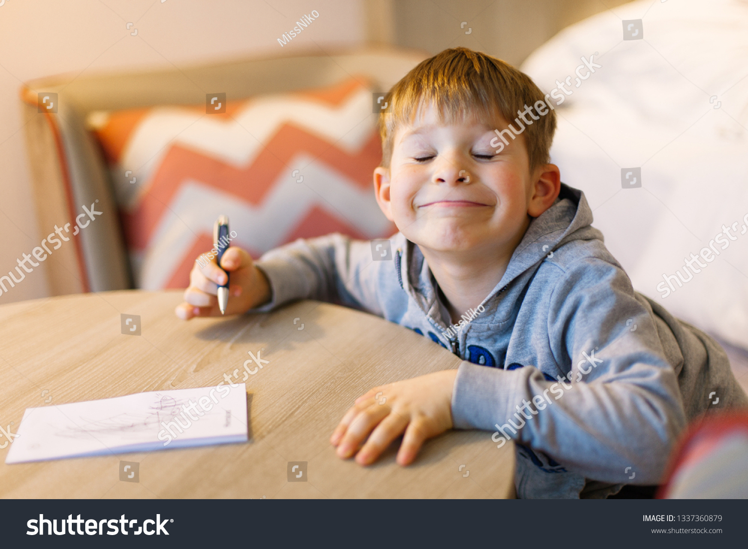Cute boy doing homework, coloring pages, writing and painting. Children paint. Kids draw. Preschooler with books at home. Preschoolers learn to write and read. Creative boy #1337360879