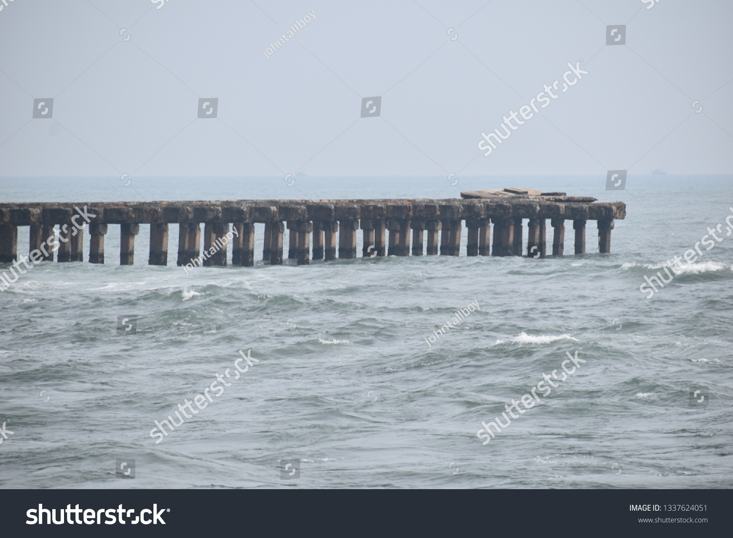 Broken bridge and broken pillars at seashore  #1337624051