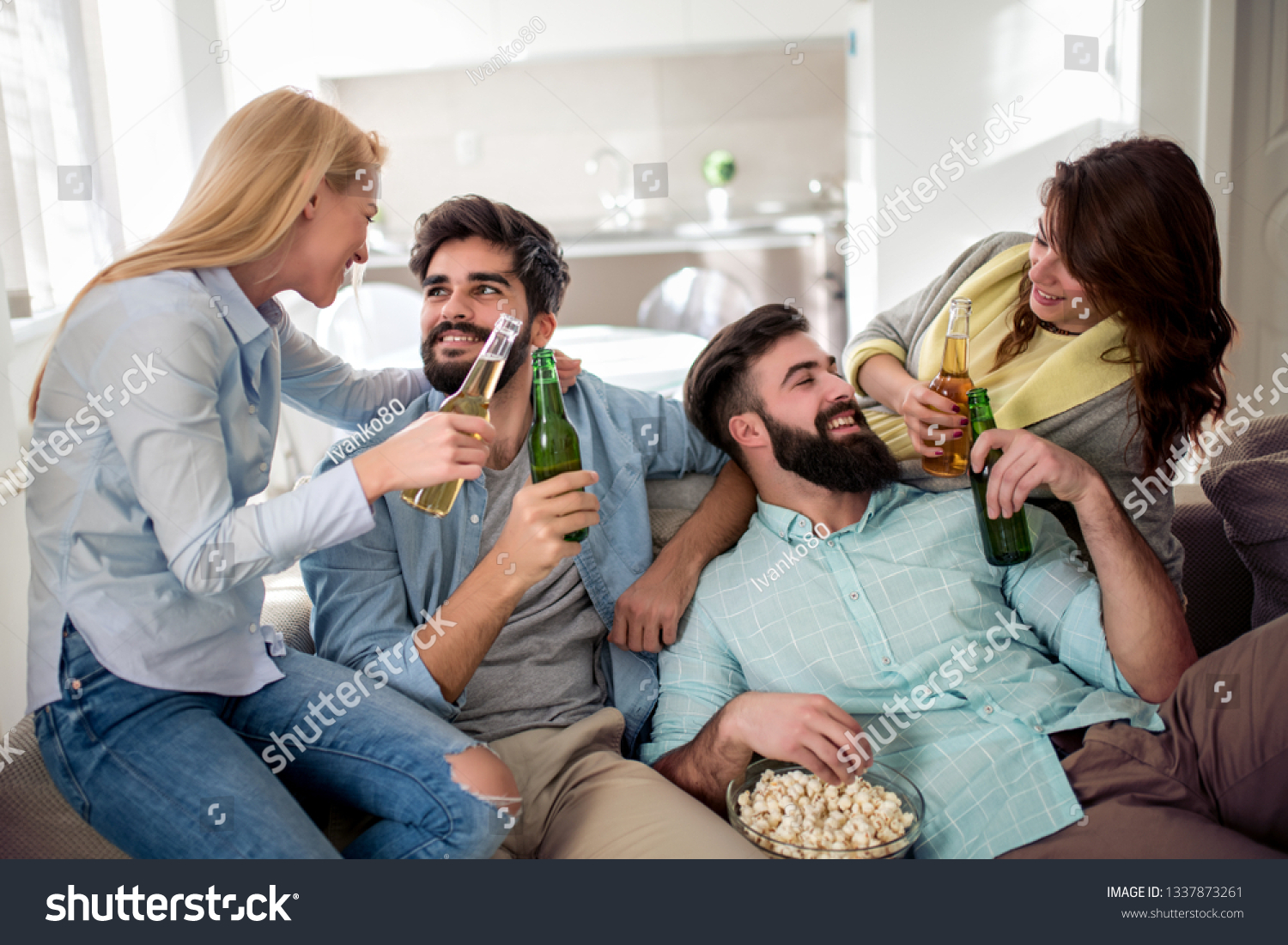 Group of friends sitting on the couch and watching football game. Friendship and party concept. #1337873261
