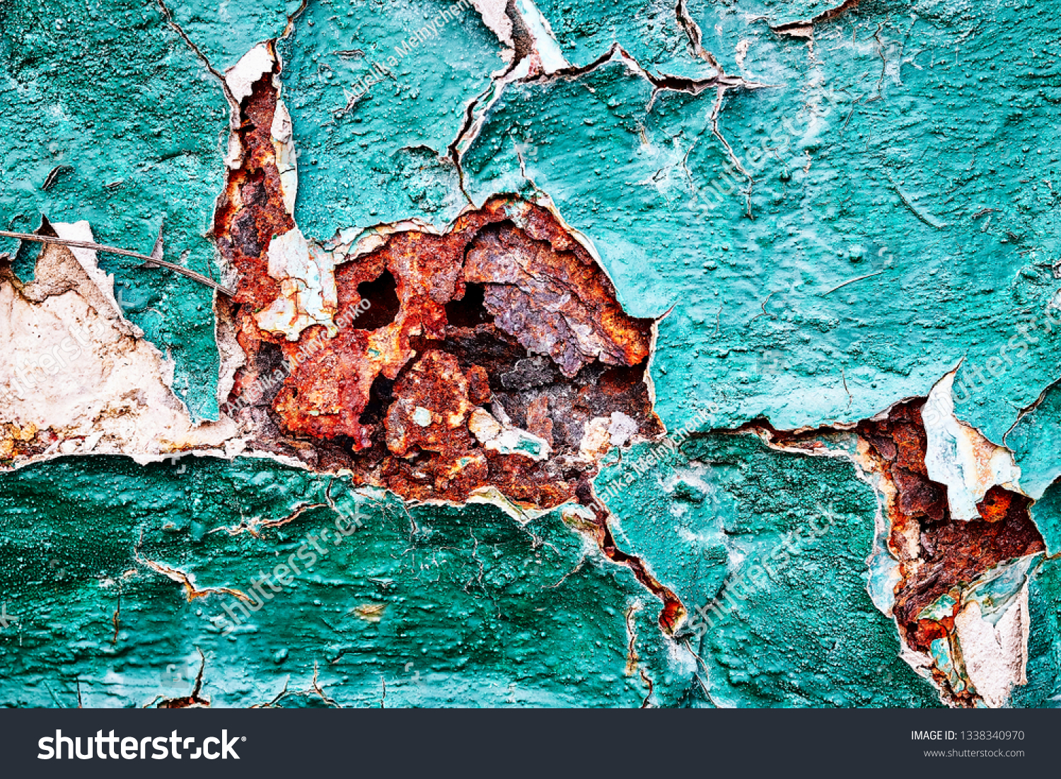 Background texture relief structure age-related changes in metal corrosion chipped cracks cracking rust pieces peeling erosion peeling green paint with white and red inserts wall surface large fragmen #1338340970