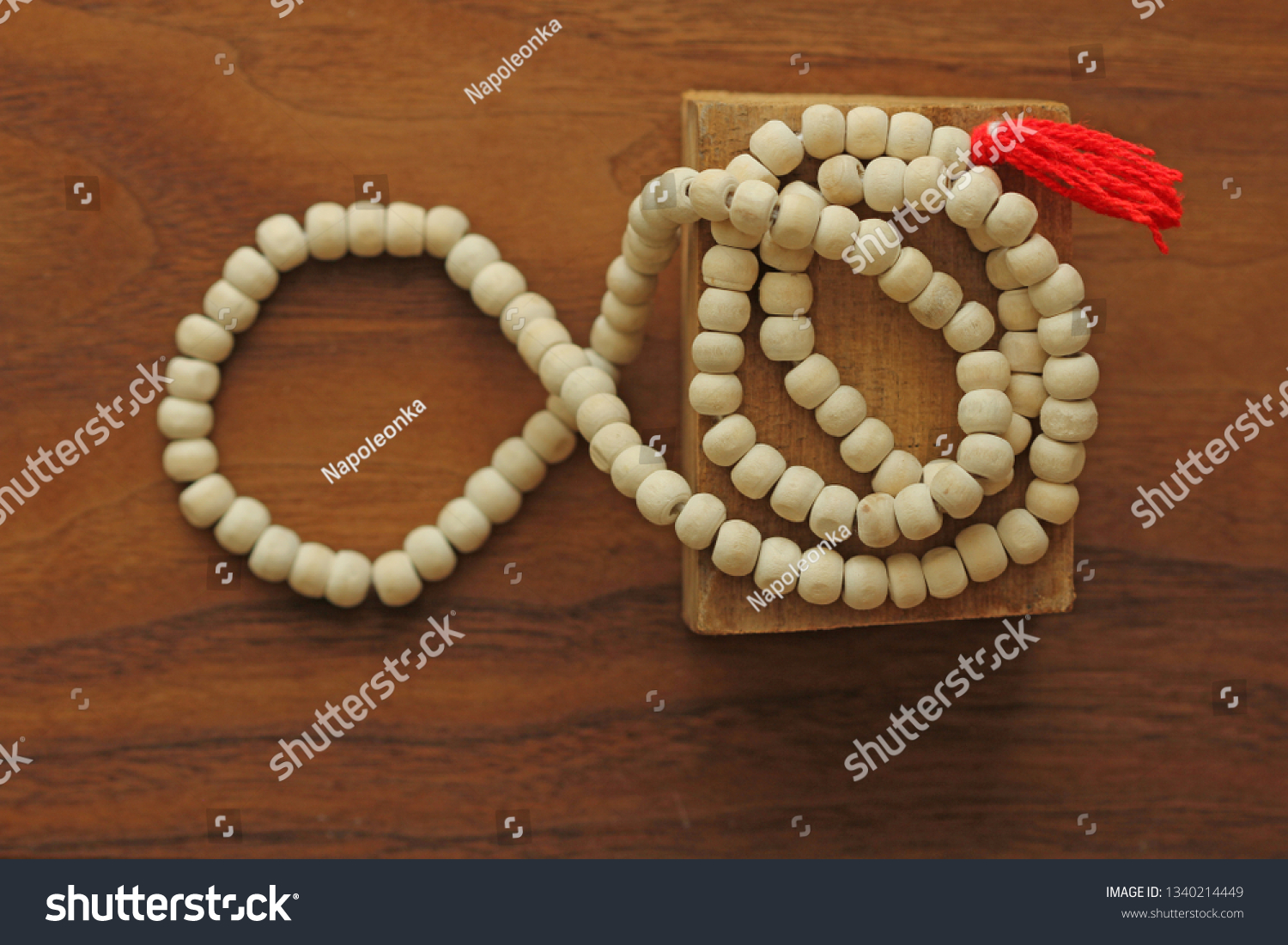 Buddhist beads. Rosary or beads from the sacred tree of Tulasi with a red tassel. #1340214449