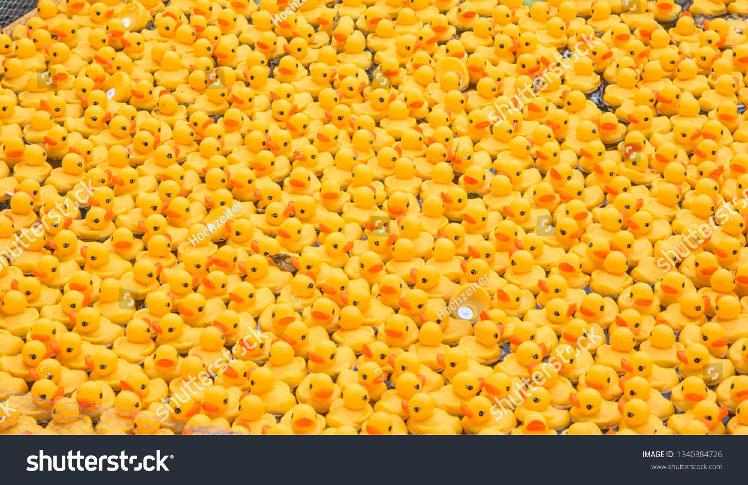 Hundreds of yellow plastic ducks with red spouts are swimming in the water somewhere. It looks like to be a big team event and most of the participants are heading to the right direction.  #1340384726