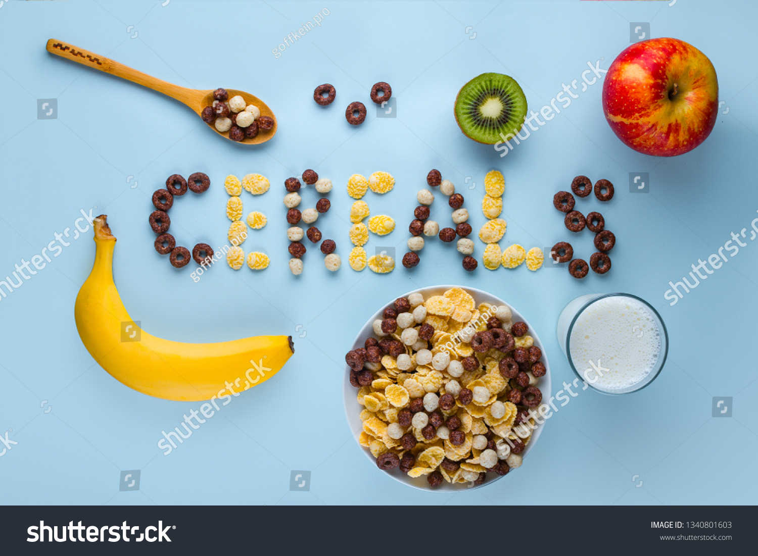 Bowl and spoon with dry chocolate balls, rings, corn flakes, glass of milk and fresh ripe fruits for healthy fiber cereals breakfast. Cereals concept  #1340801603