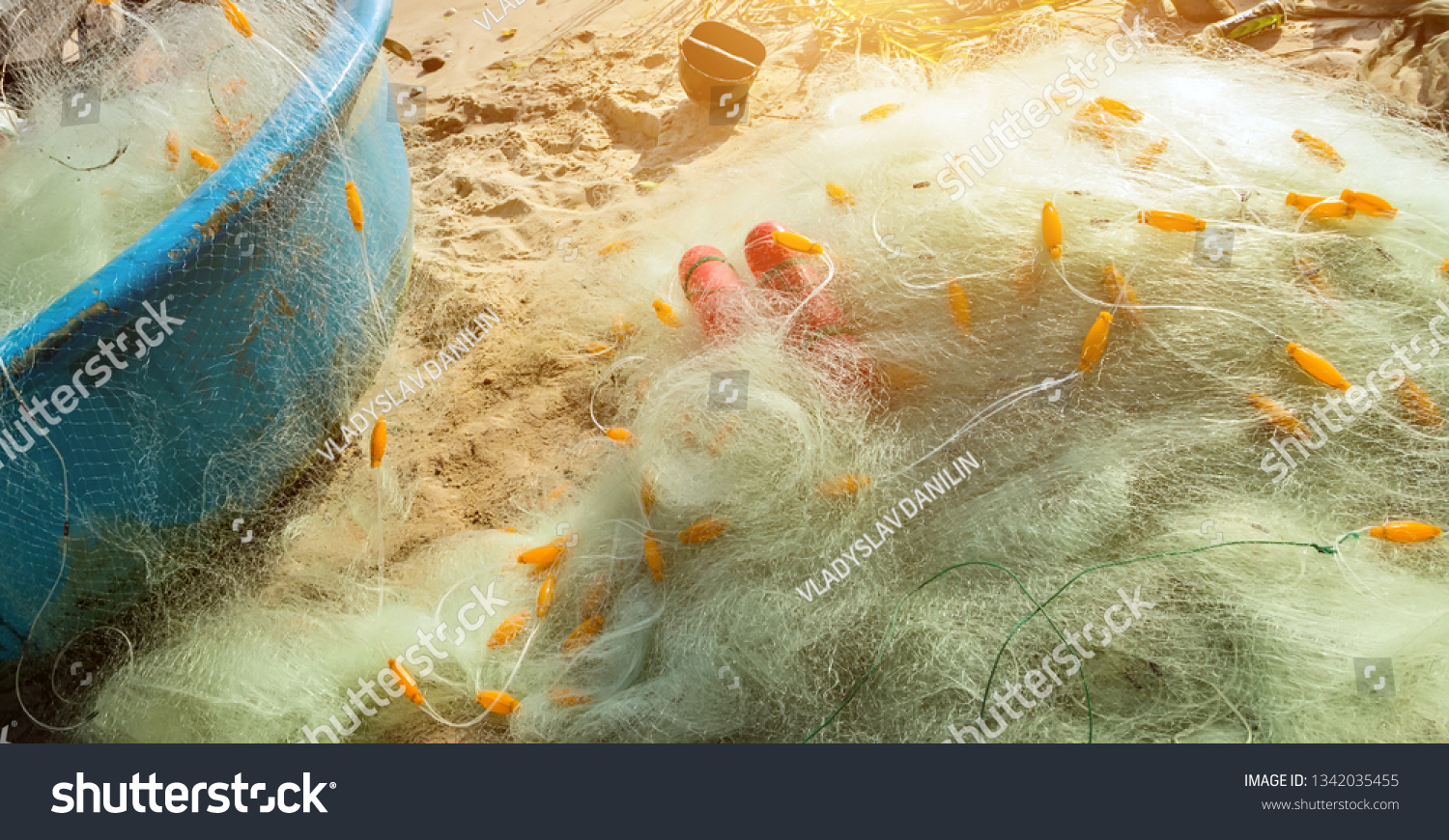 Nylon fishing net with float line attached to small plastic floats in the basket boats on the beach Vietnam #1342035455