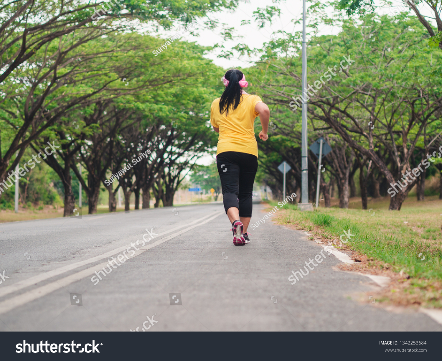 Overweight woman running in the park. Weight loss concept #1342253684