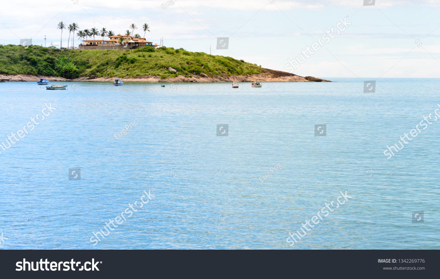 A lovely bay with some little boats and a  sand beach in Meaìpe a small fishing village near Guarapari in the Espirito Santo state in Brazil #1342269776