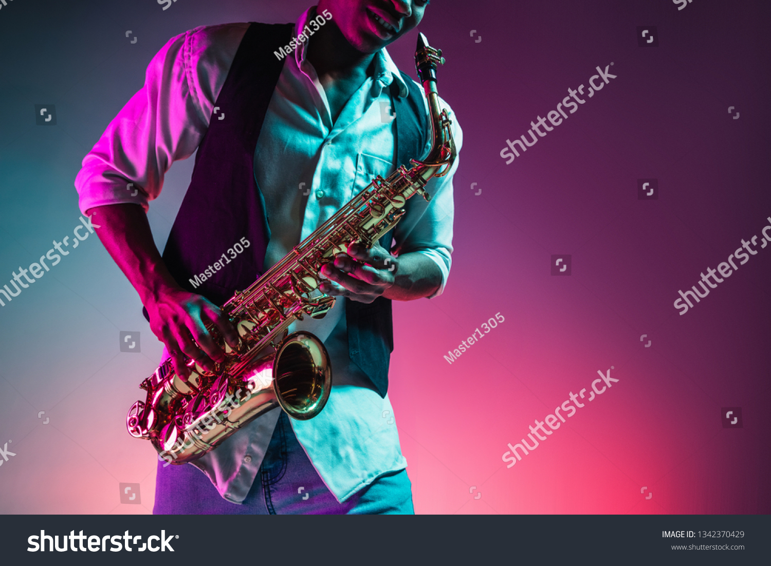 African American handsome jazz musician playing the saxophone in the studio on a neon background. Music concept. Young joyful attractive guy improvising. Close-up retro portrait. #1342370429