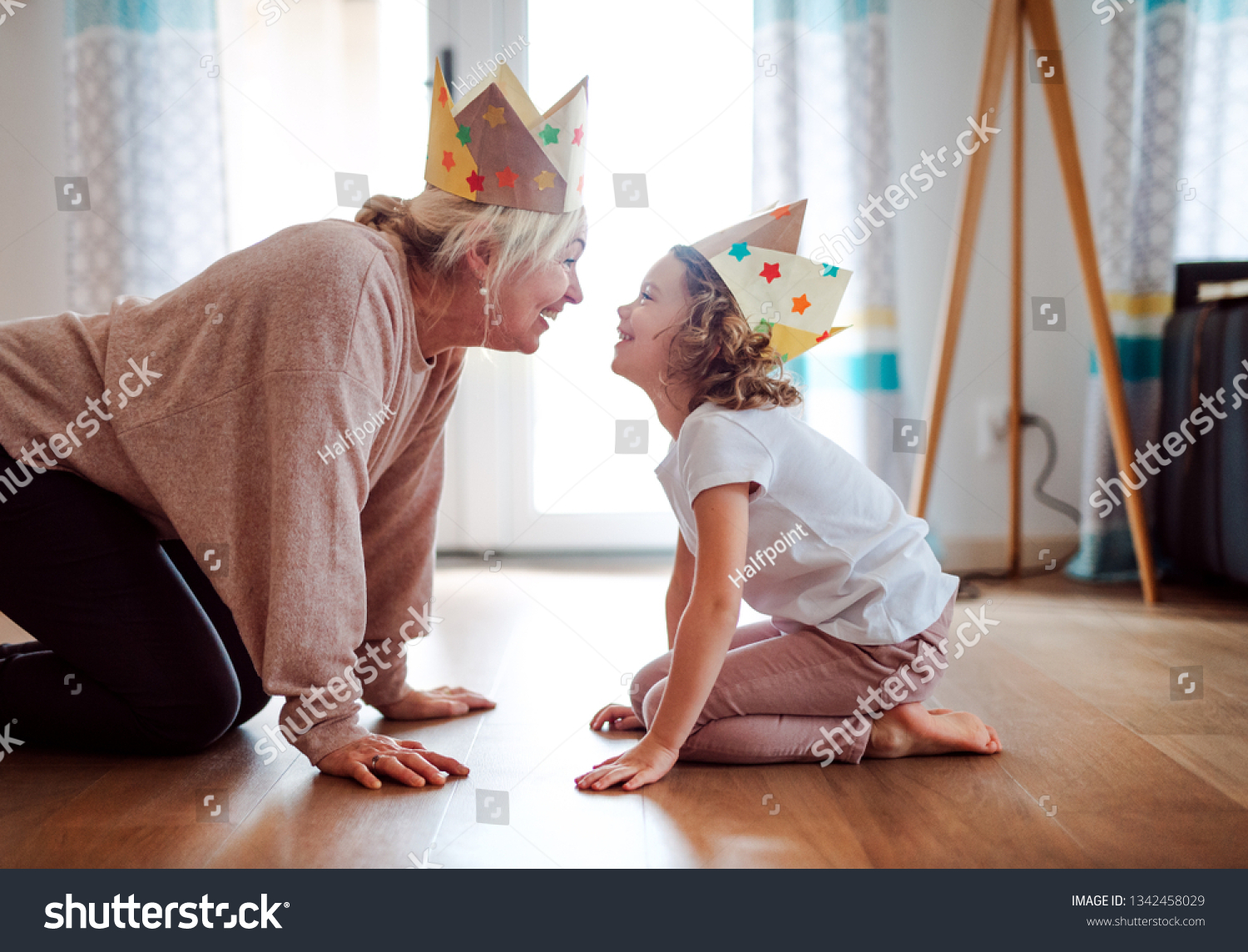 A portrait of small girl with grandmother having fun at home. #1342458029