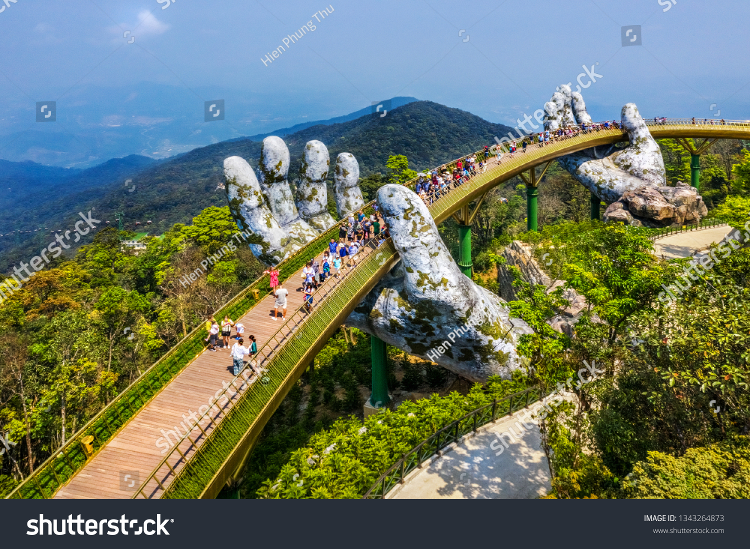 Aerial view of the Golden Bridge is lifted by two giant hands in the tourist resort on Ba Na Hill in Da Nang, Vietnam. Ba Na mountain resort is a favorite destination for tourists #1343264873