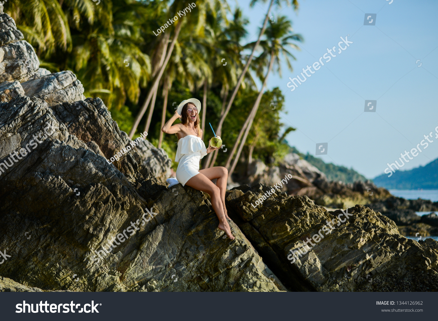 Beautiful girl on the beach with coconut in Thailand #1344126962