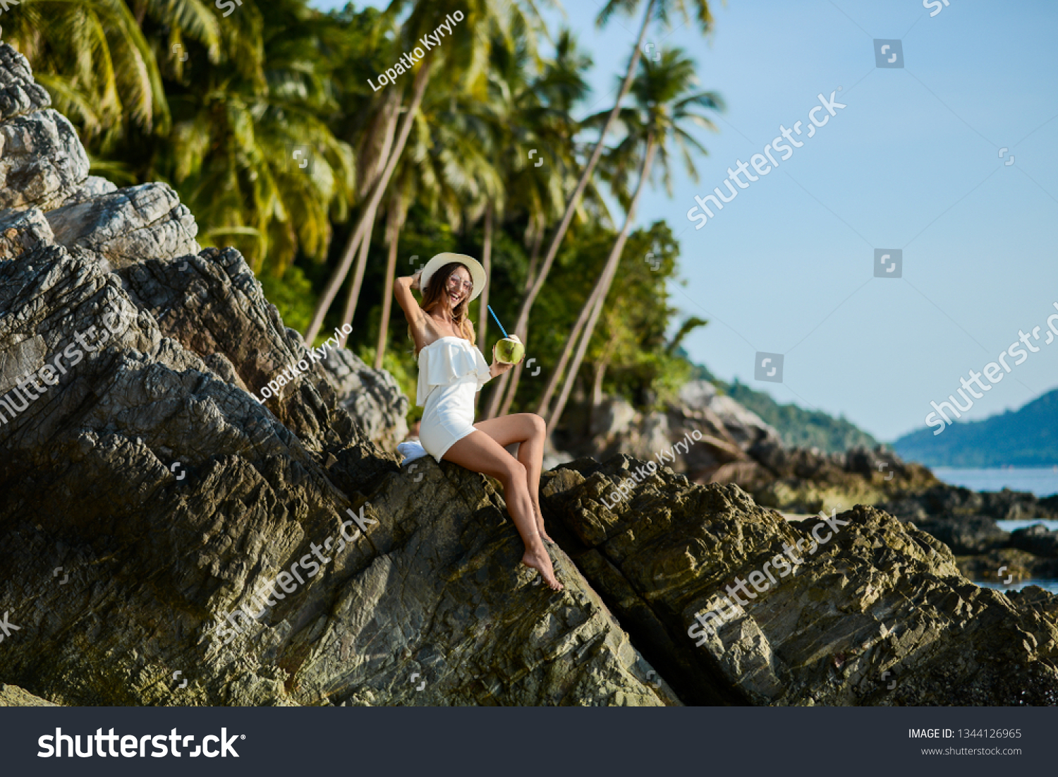 Beautiful girl on the beach with coconut in Thailand #1344126965