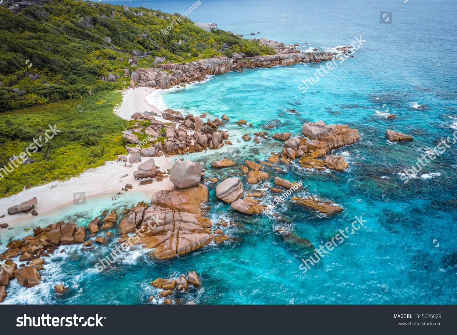Aerial view of Seychelles tropical Marron beach at La Digue island. White sand beach with turquoise ocean water and quaint granite rocks. tropical paradise #1345626029