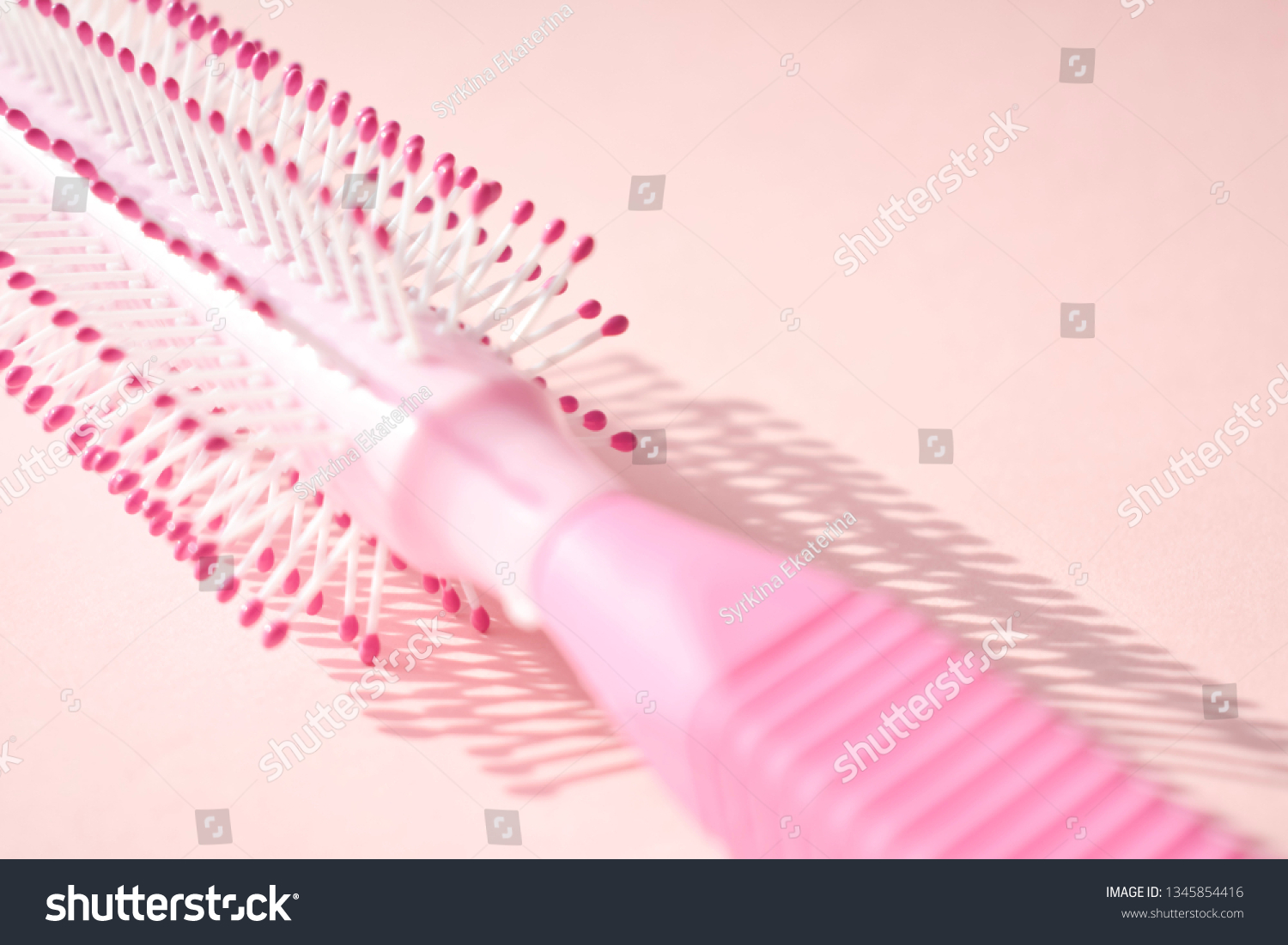Pink comb on white background. Background. Hygienic environments. Personal hygiene. Hygiene products. Hair. To comb the hair. #1345854416