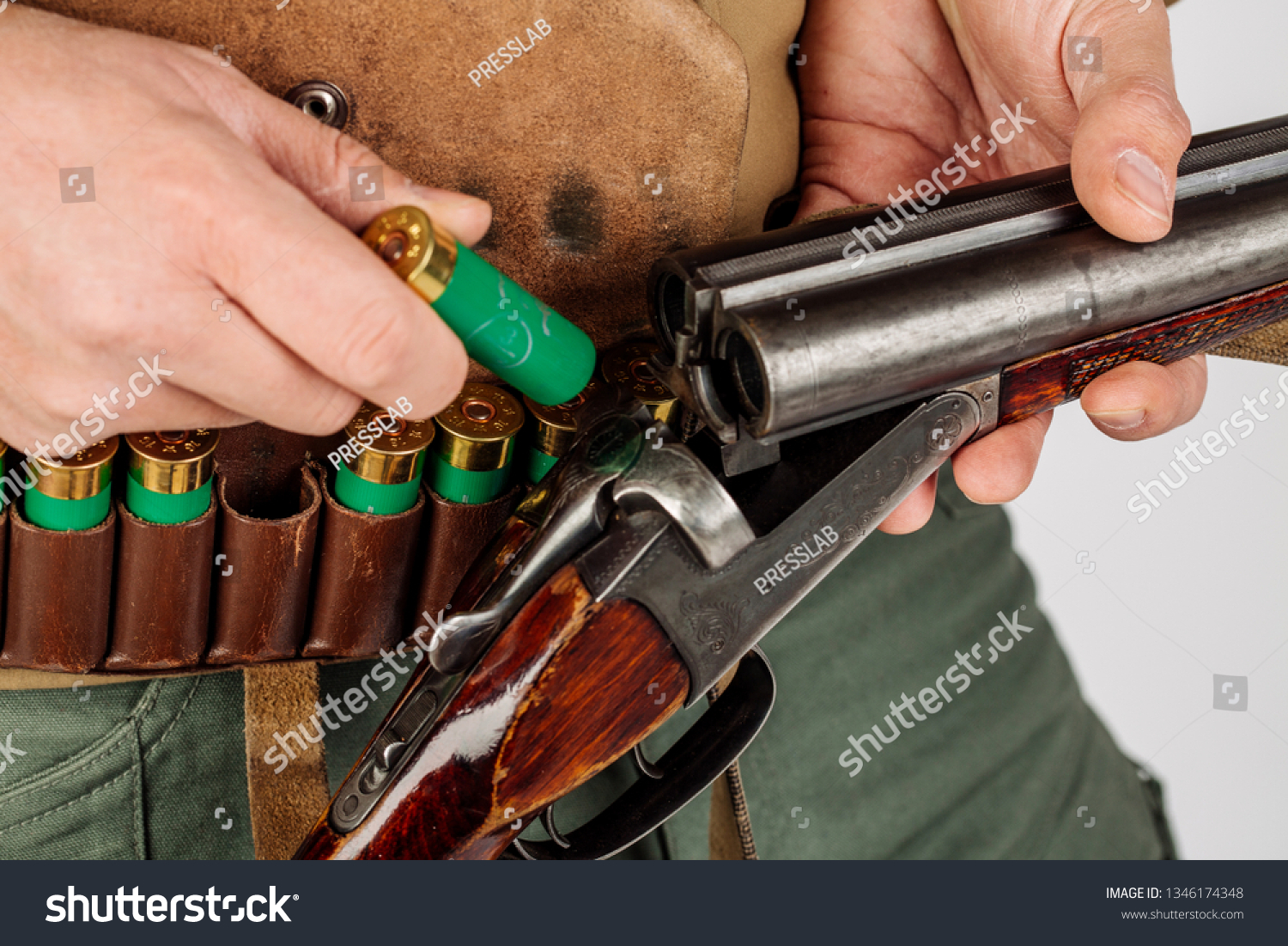 Men's hands with a hunting gun reload the cartridge #1346174348