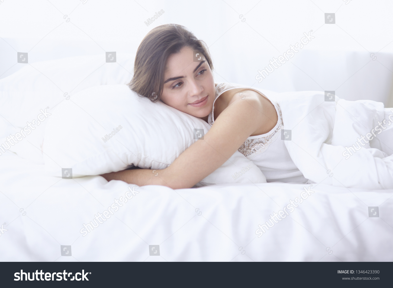 beautiful young woman basking in bed in the morning. Beautiful  #1346423390