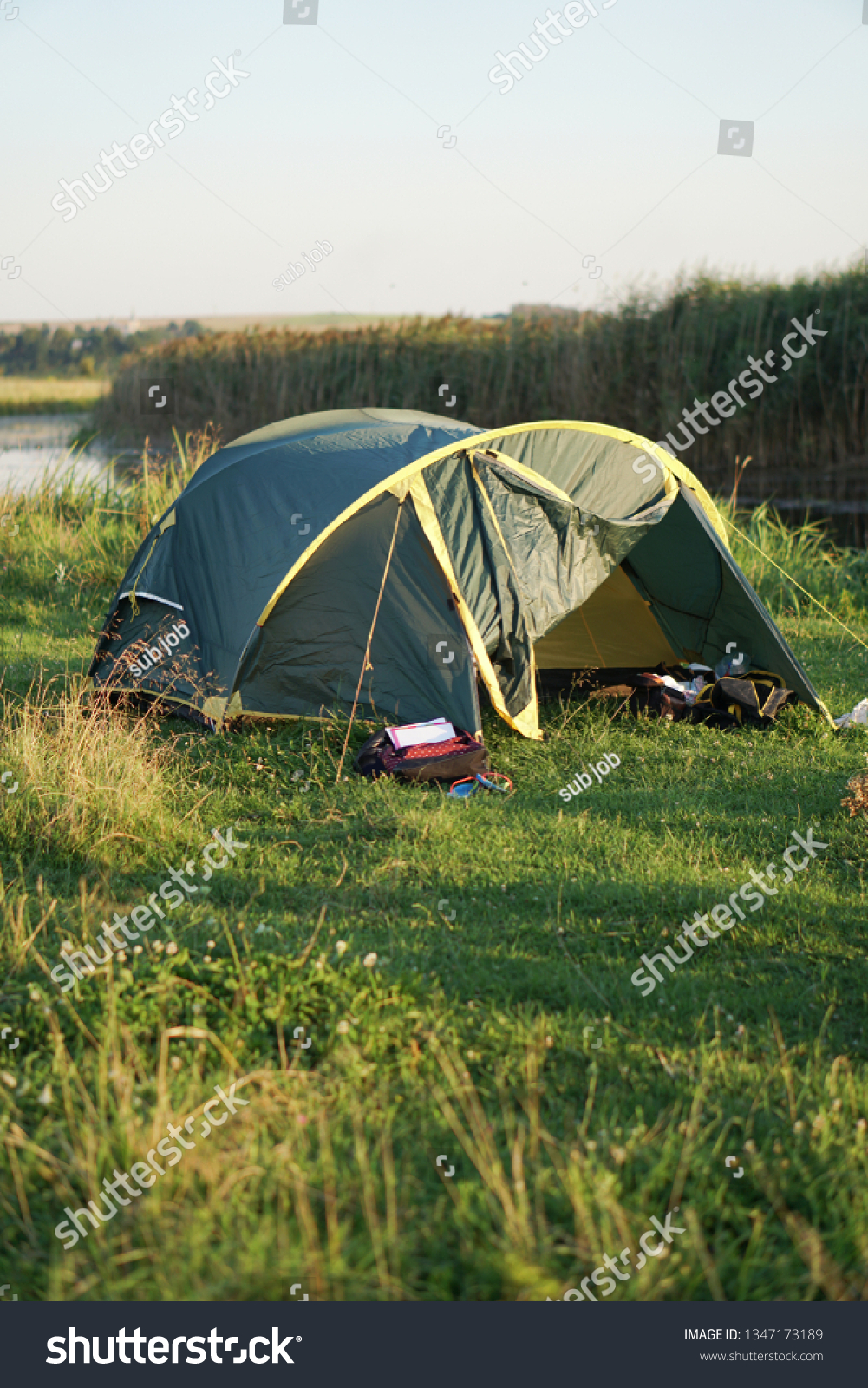 Landscape with a tent with a beautiful view near the river. Spring summer outdoor recreation. Stock background, photo #1347173189