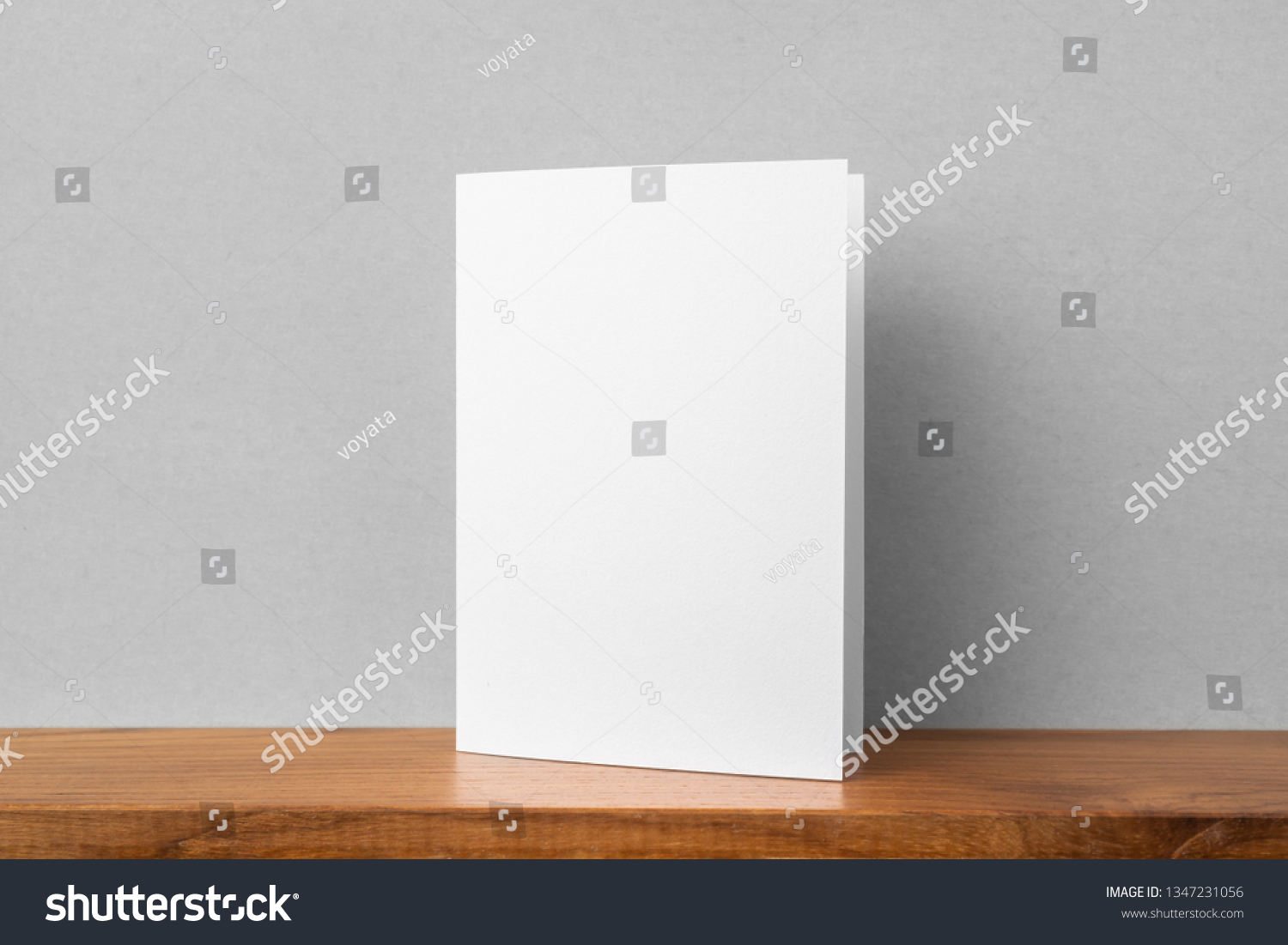 Design concept - front view of greeting card on bookshelf and grey wall for mockup, not 3D render #1347231056