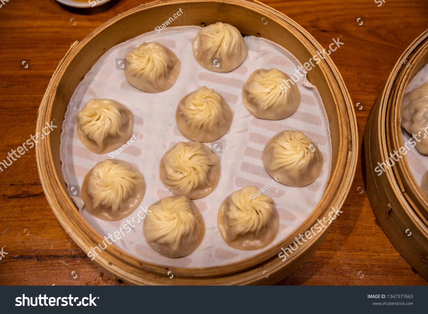 Chinese steamed steamed bun ( baozi ) named Xiaolongbao also called a soup dumpling. It is traditionally prepared in xiolong small bamboo steaming basket. #1347377663