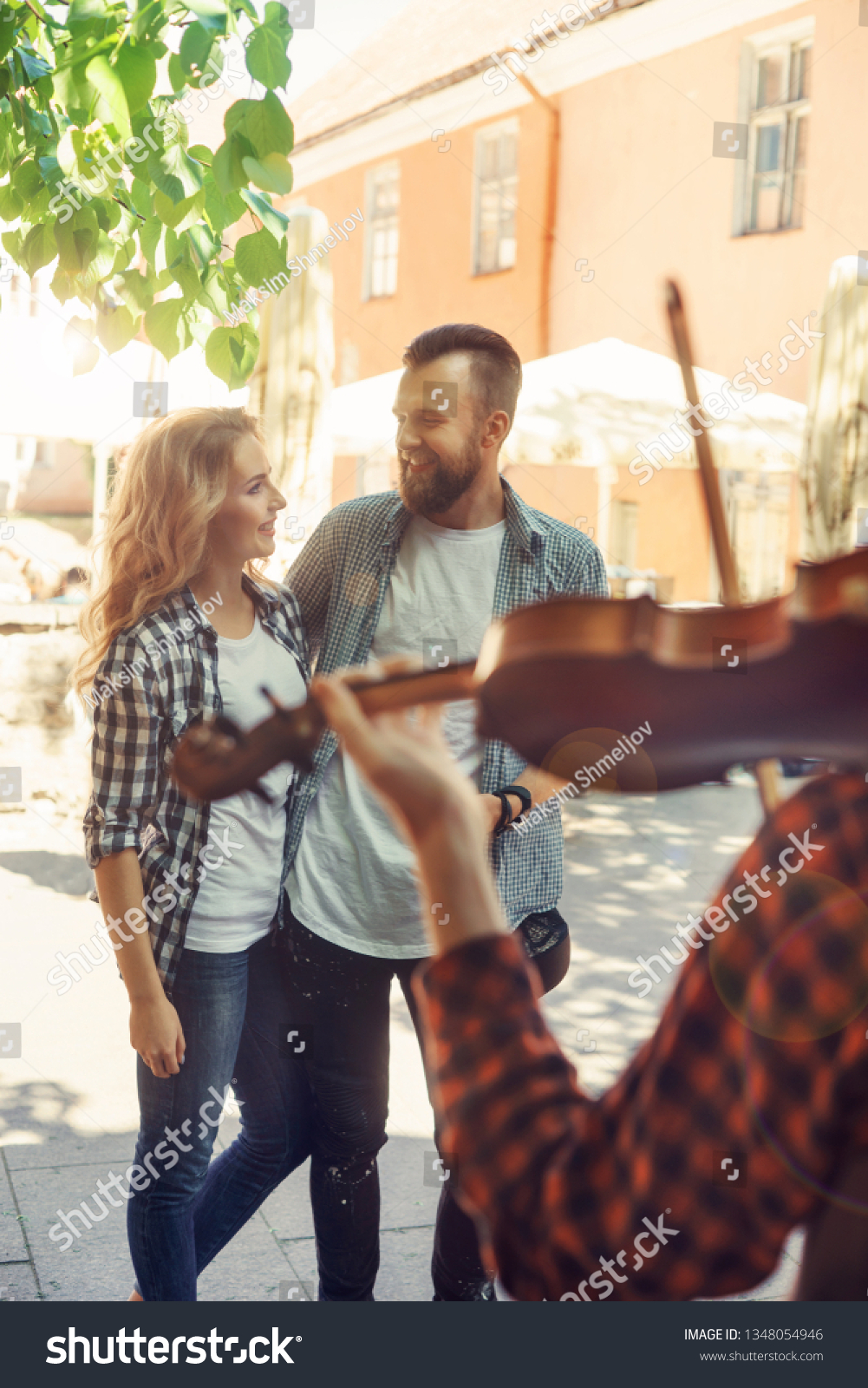 Young loving couple enjoying street musician with a violin #1348054946