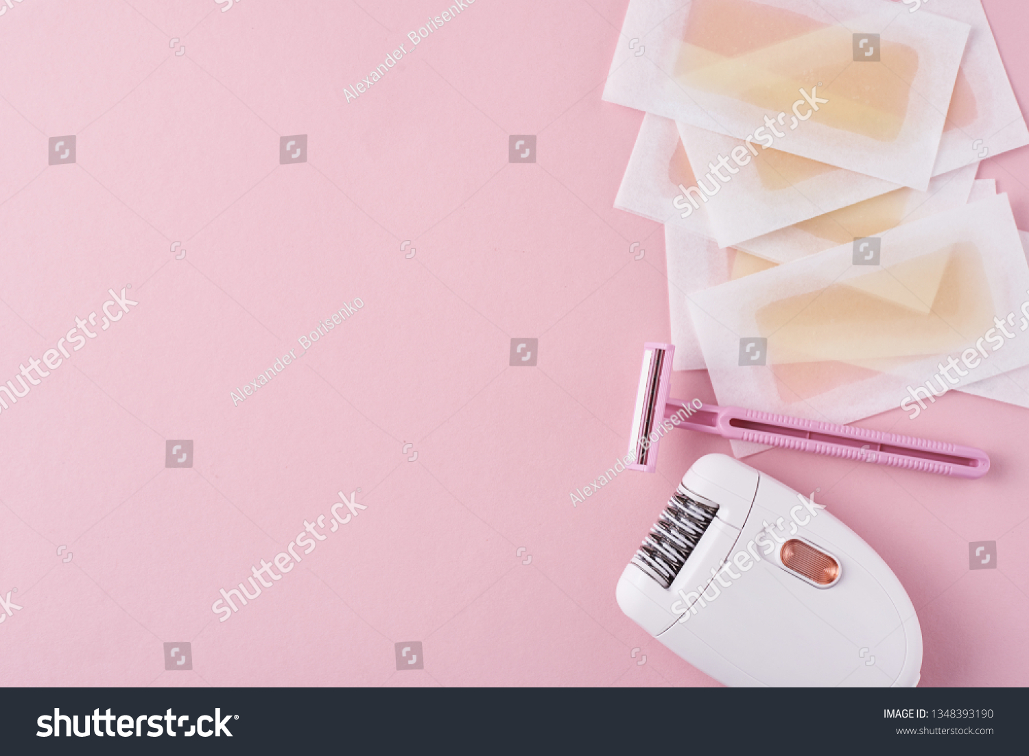Epilator, razor for shaving and wax strips on pink background with copy space. Set for depilation, bodycare concept #1348393190