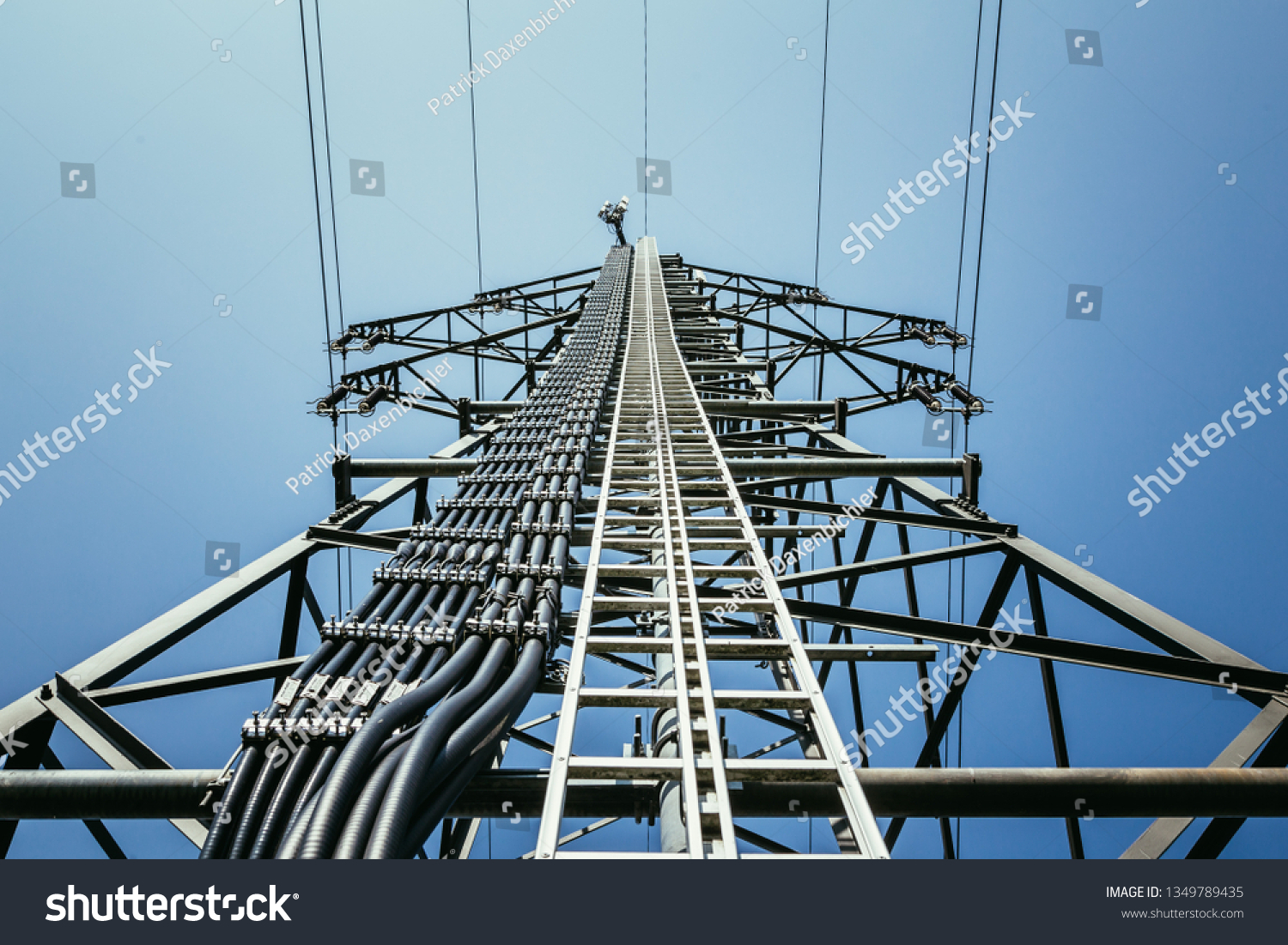 Picture of an electrical tower or pylon, blue sky in the background. Power grid or smart grid.  #1349789435