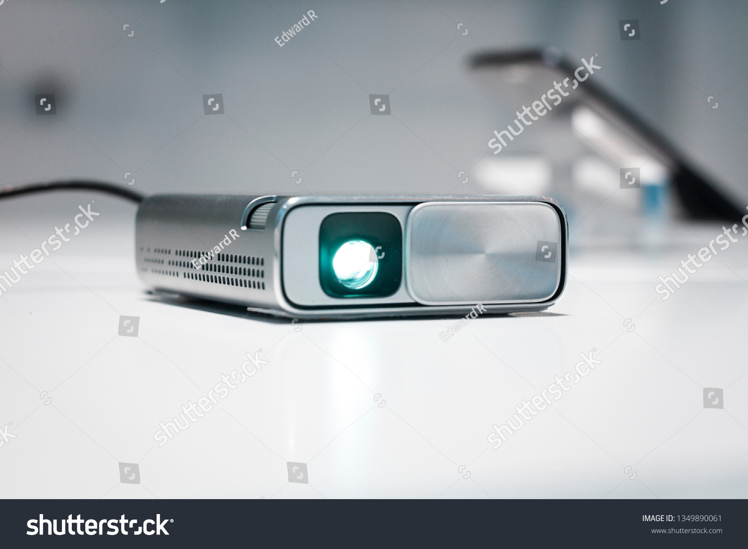 Security and CCTV mini device for any kind of surveillance. Small silver body, high resolution camera sensor, and lens. Futuristic design, spy game. Privacy and personal data issues, pocket projector. #1349890061