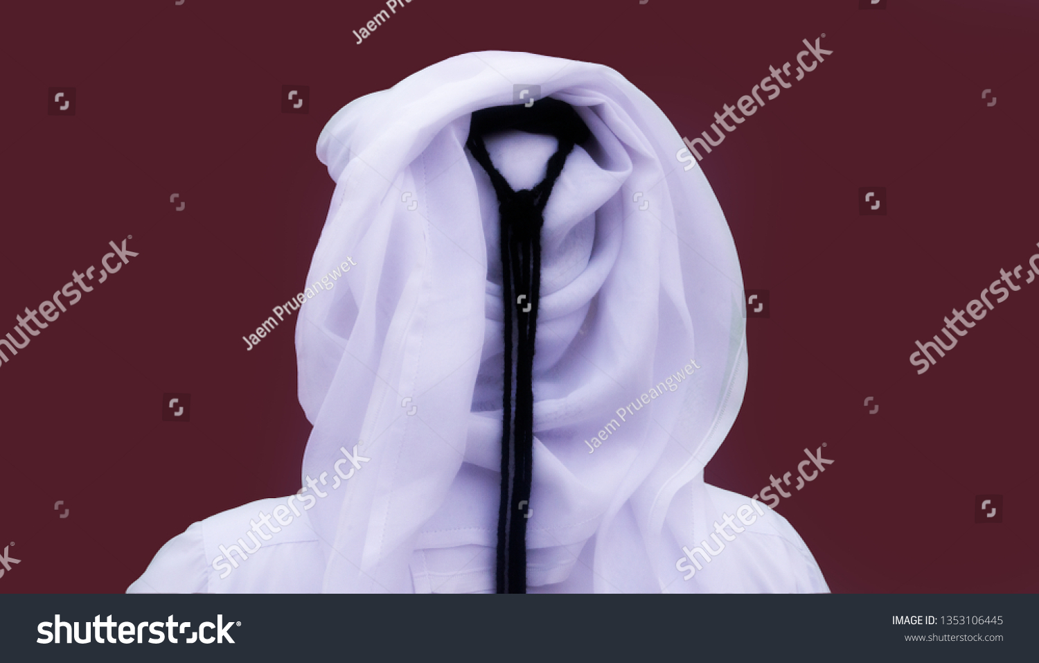 Portrait of an unknown Qatari man from behind in a traditional uniform isolated on maroon background #1353106445