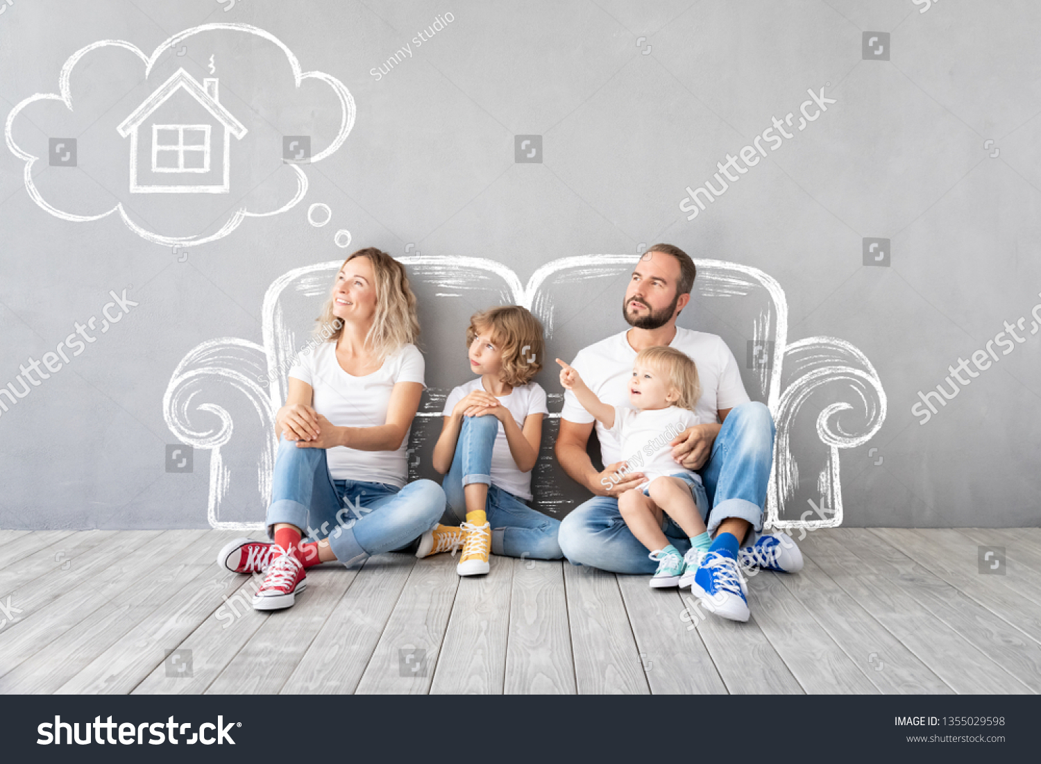 Happy family with two kids playing into new home. Father, mother and children having fun together. Moving house day and real estate concept #1355029598